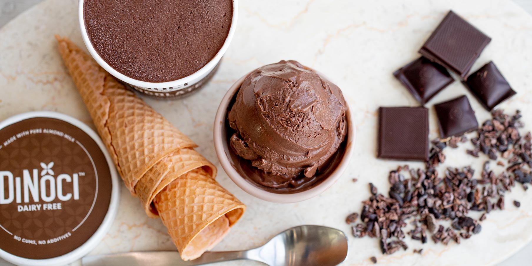 Dinoci chocolate icecream with empty cones and chocolate bits