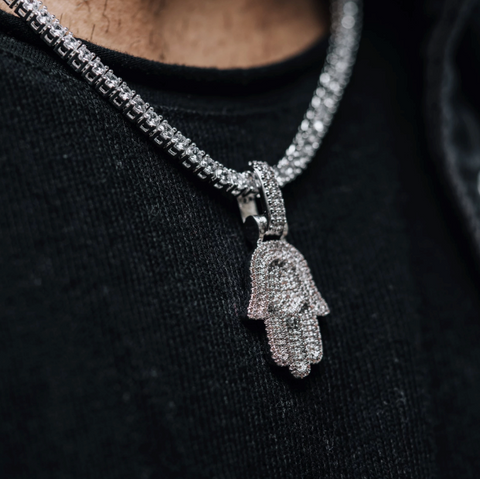 Un collier hamsa en or blanc.