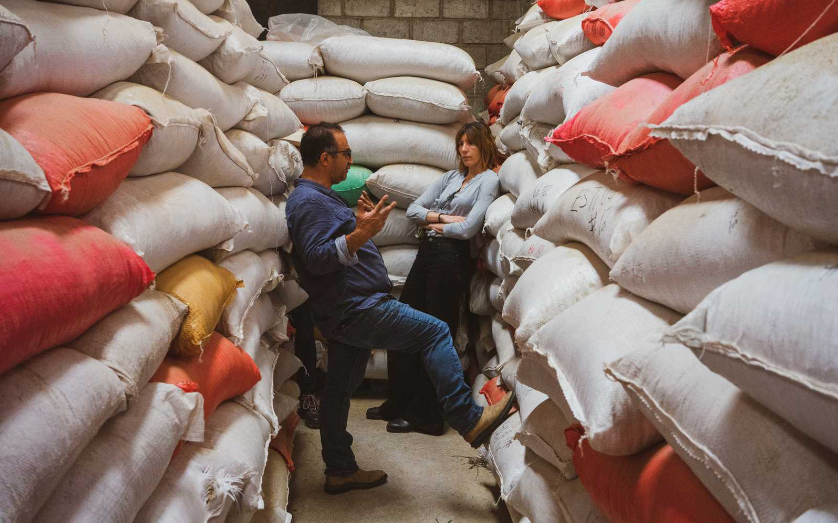 Coffee growers next to bags of green coffee beans.