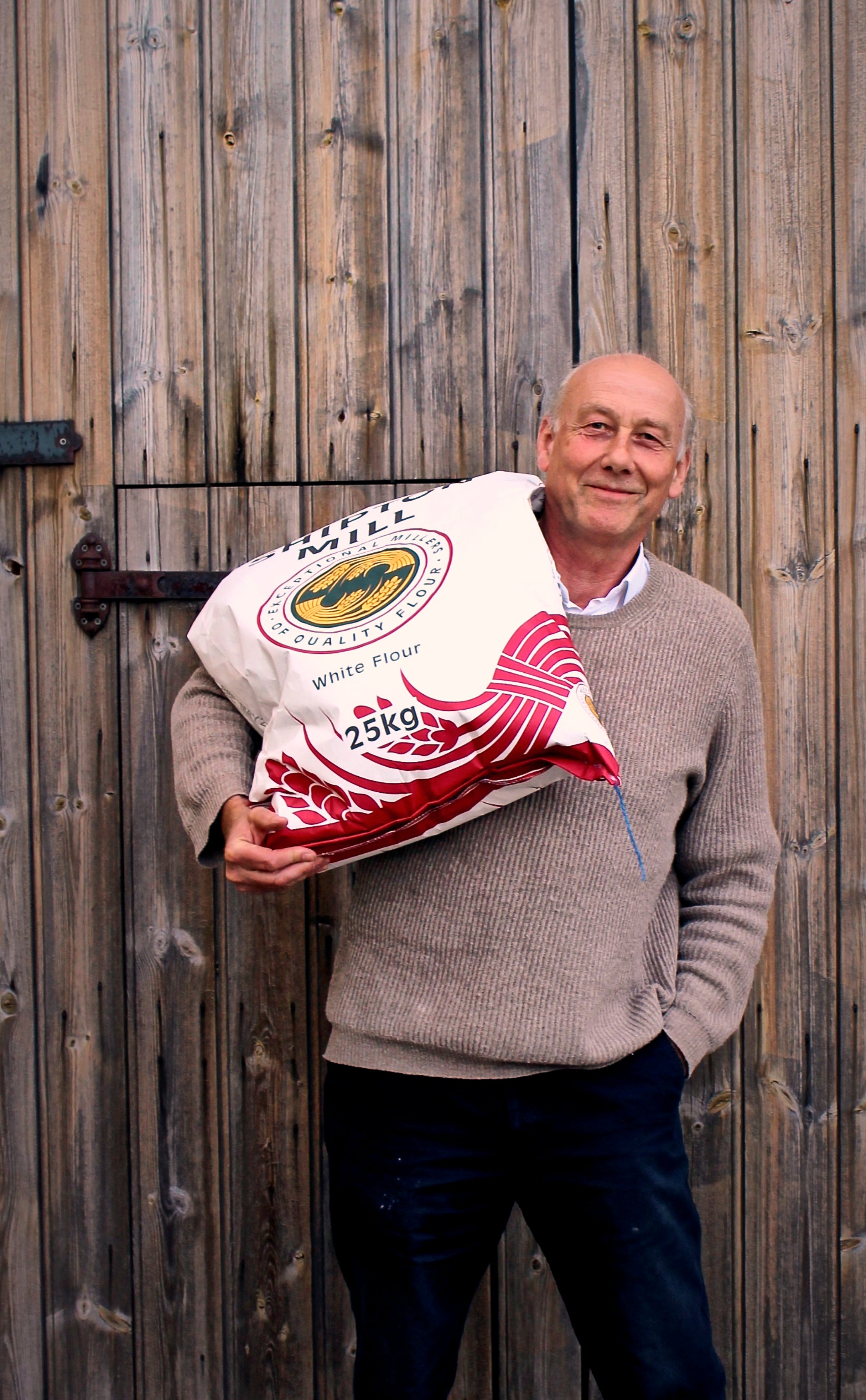 Farmer carrying a bag of flour on his shoulder