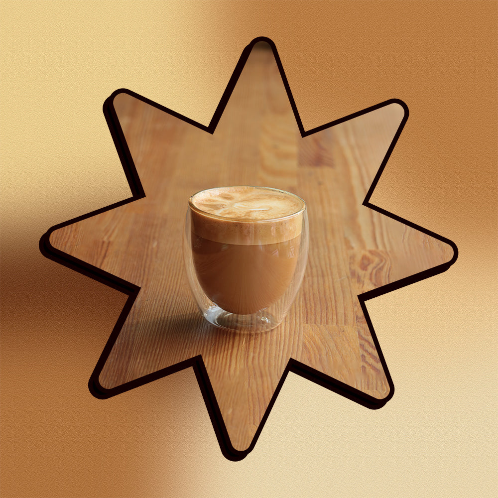 A simple macchiato on a wooden surface in a star shape on a mesh gradient background.