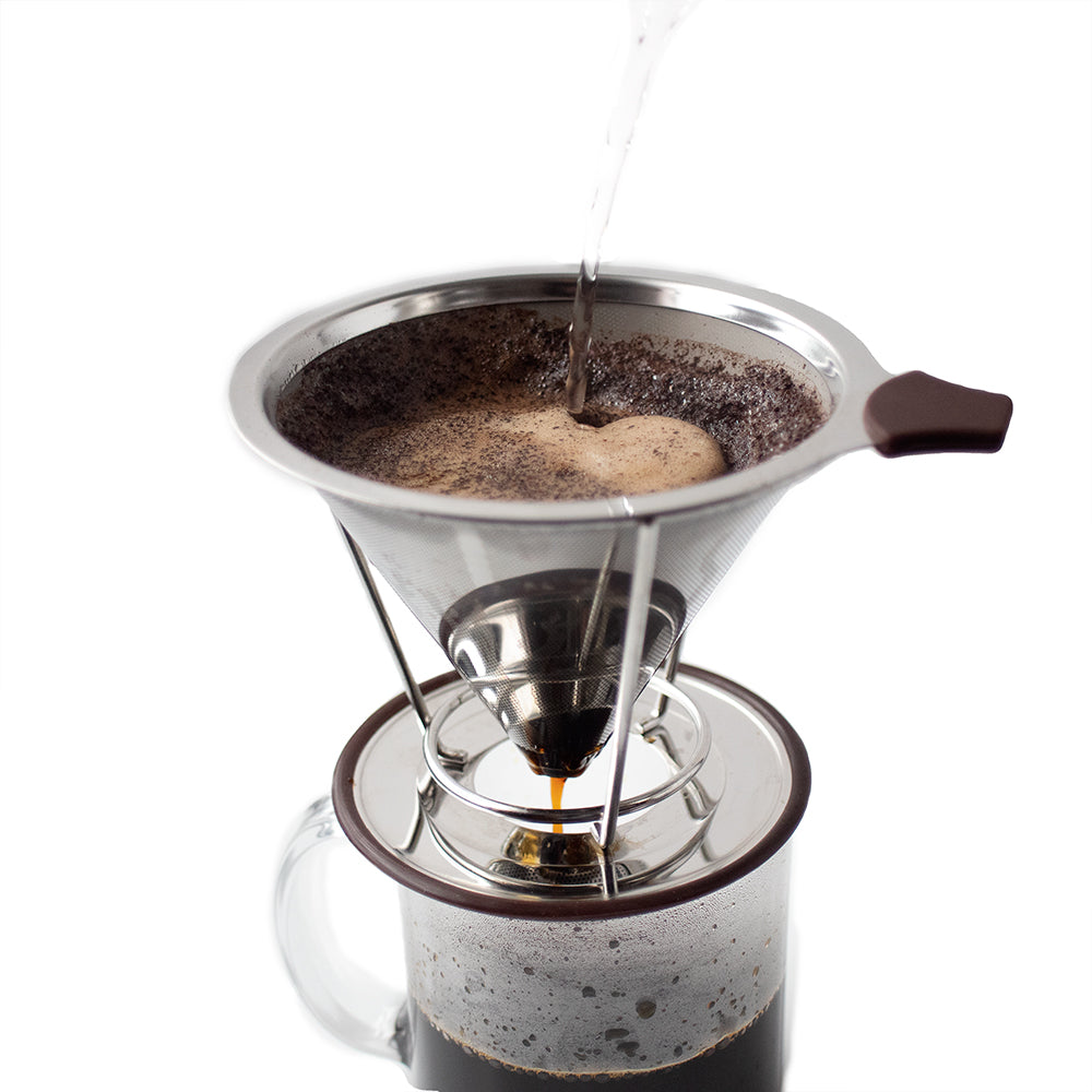 Water being poured over coffee grounds in a stainless-steel filter over a glass mug.