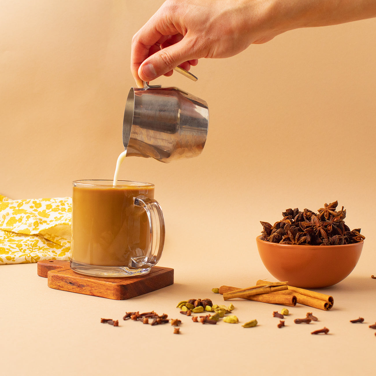 An iced chai latte with cardamom pods, cloves, cinnamon sticks, and star anise.