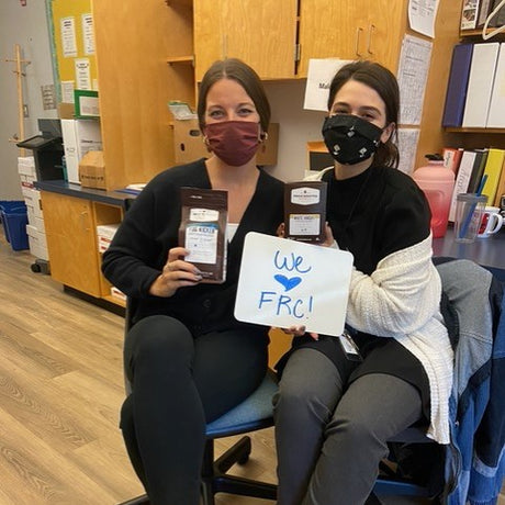 Two teachers pose with FRC coffee