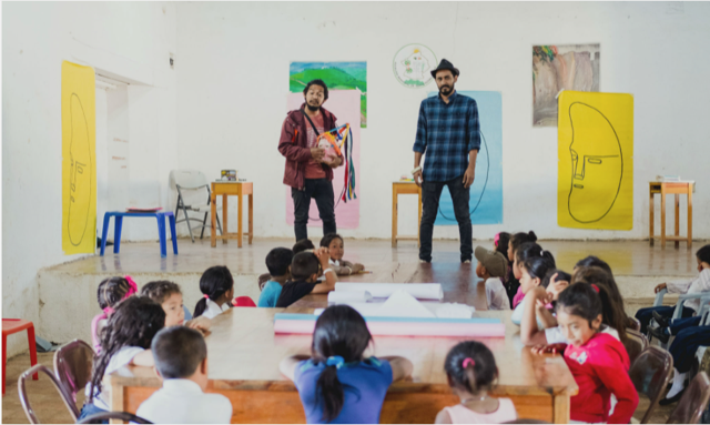 Honduran men talk to a group of school children.