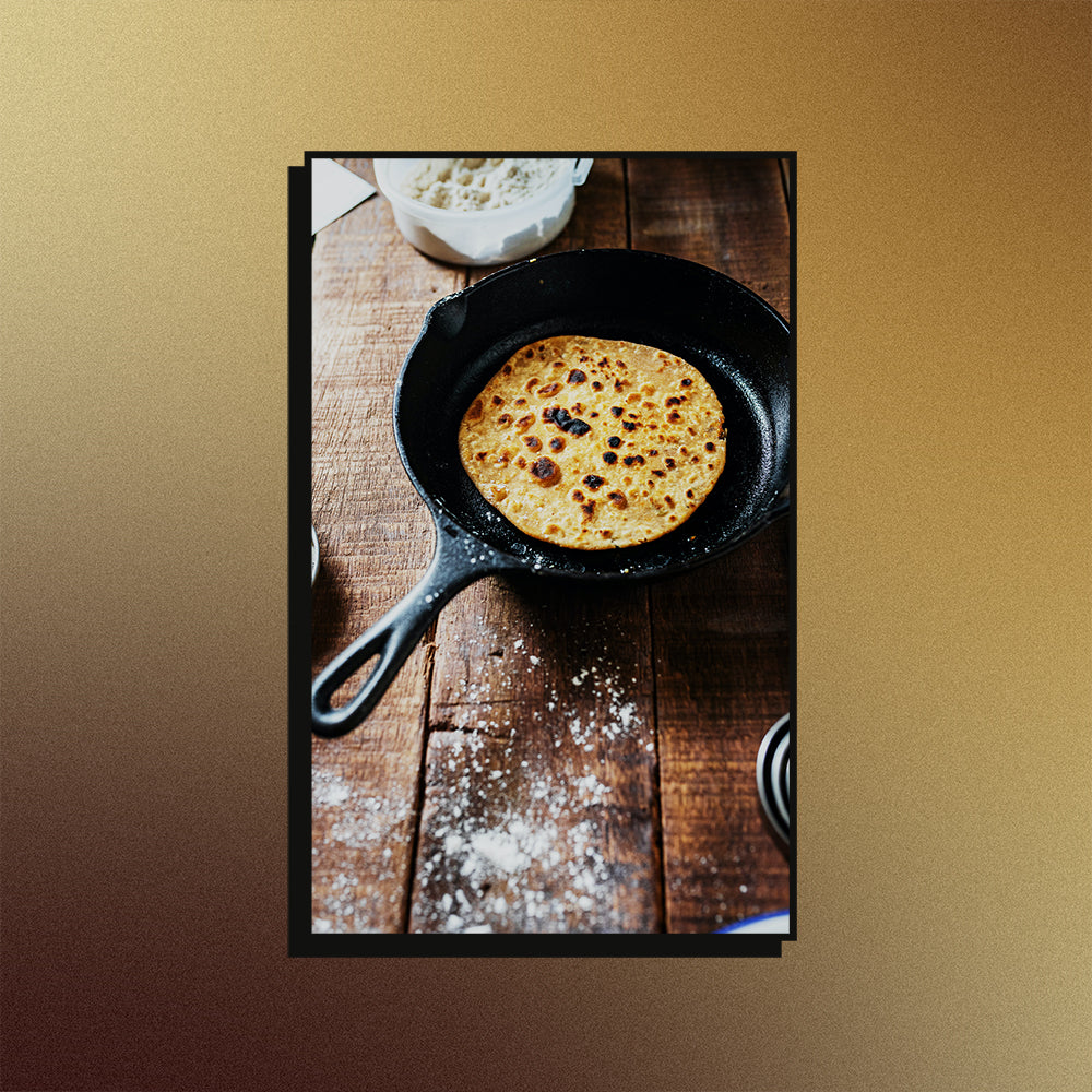 An image of a cast-iron skillet on a mesh gradient background.