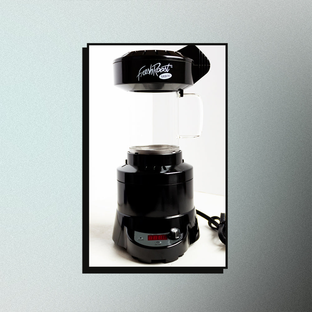 An image of an SR800 home coffee roaster on a mesh gradient background.