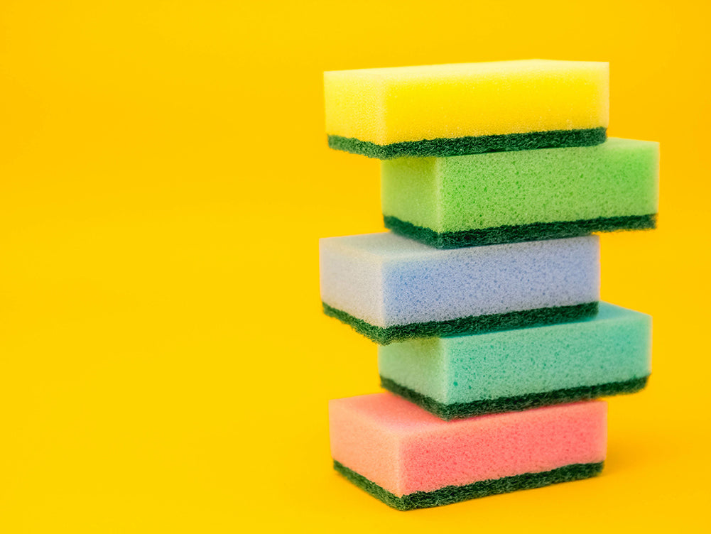 A stack of abrasive sponges on a yellow background.