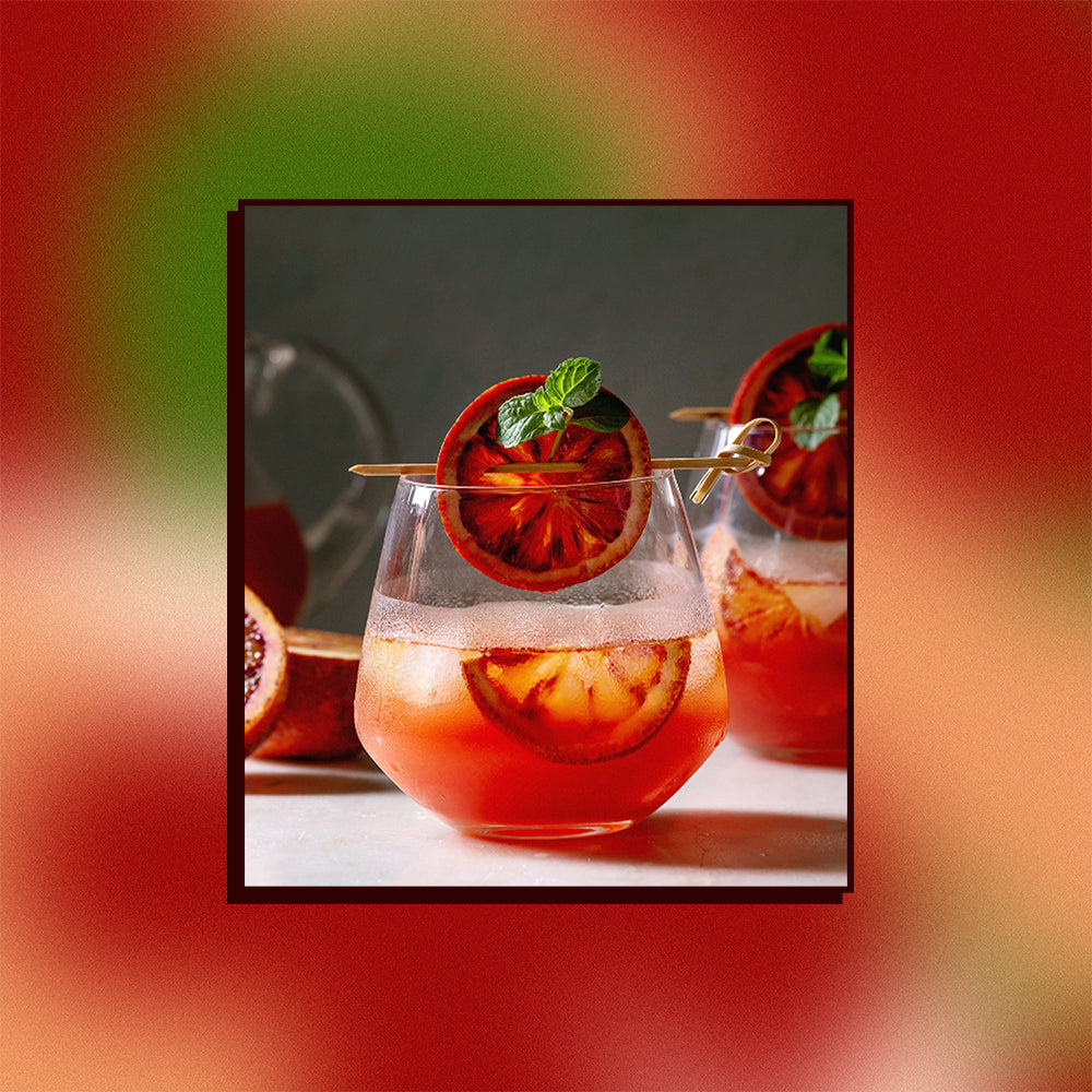 An image of blood orange punch on a mesh gradient background.