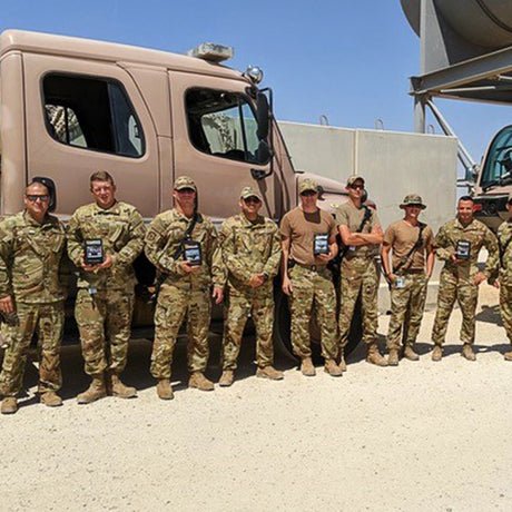 Deployed military servicemen pose together with bags of Black Knight