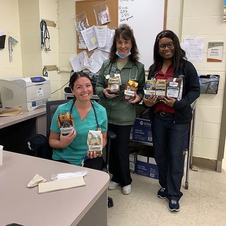 Three nurses pose with several bags of FRC blends