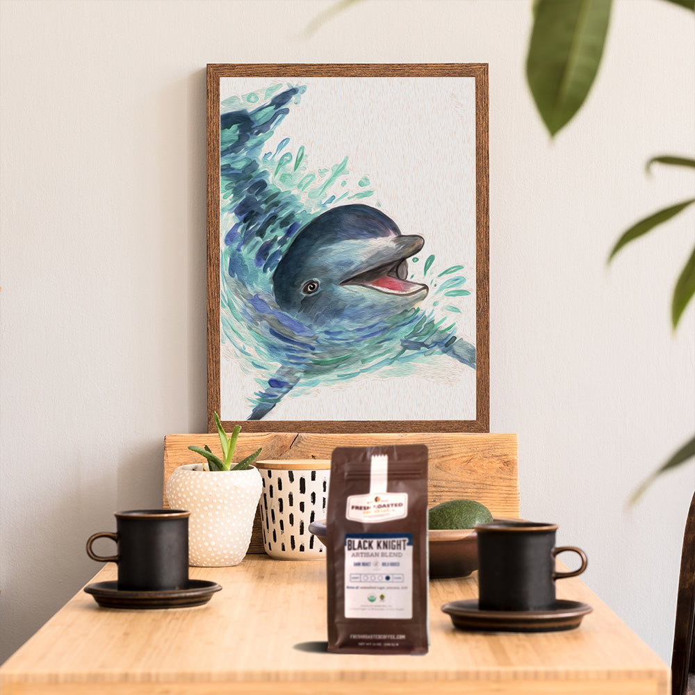 A kitchen scene with two coffee mugs, a bag of Fresh Roasted Coffee, and a framed watercolor of a dolphin.