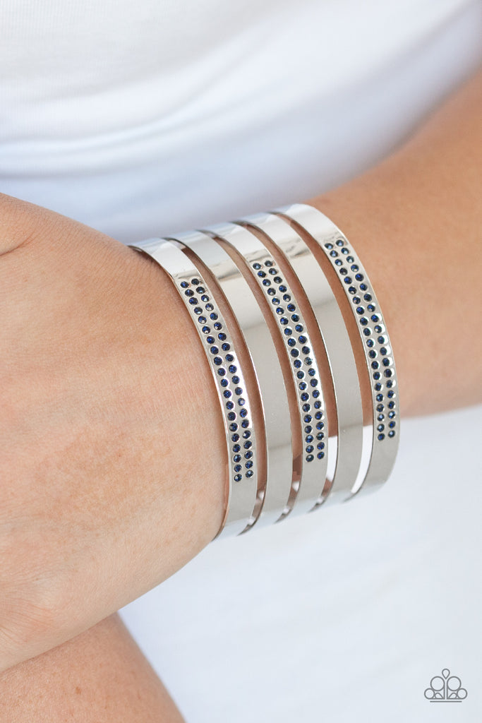 Smooth silver and glittery blue rhinestone encrusted silver bands alternate across the wrist, stacking into a statement-making cuff.  Sold as one individual bracelet.