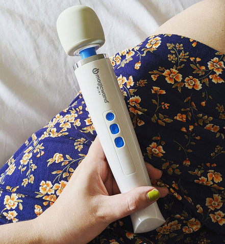 Product picture of the Hitachi Magic Wand Mini personal massager being held in the hands of a woman.