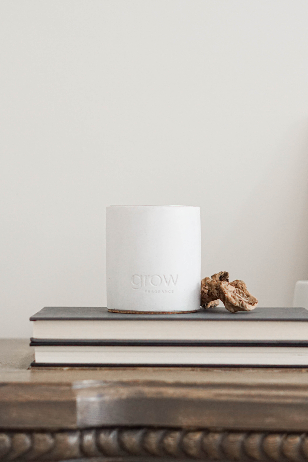 Aromatic Grow Fragrance candle on a cozy shelf with books - A thoughtful gift idea for new mothers concerned about safe candle use around their baby.