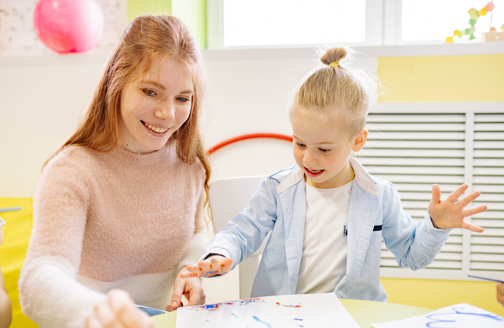 teacher and child doing finger painting