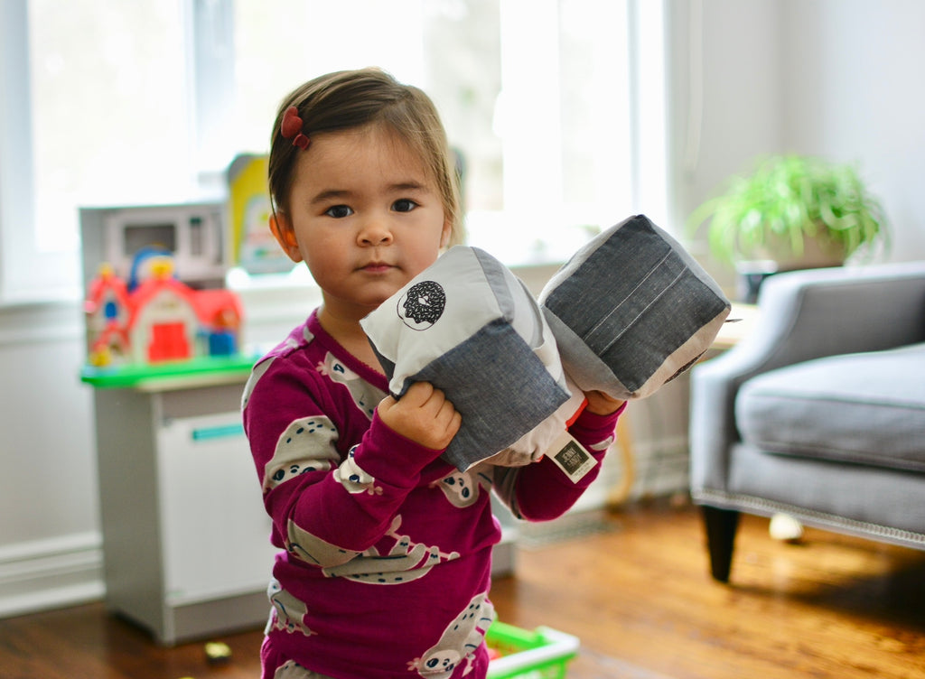 toddler holding jJenny & Andy plush rattle cubes