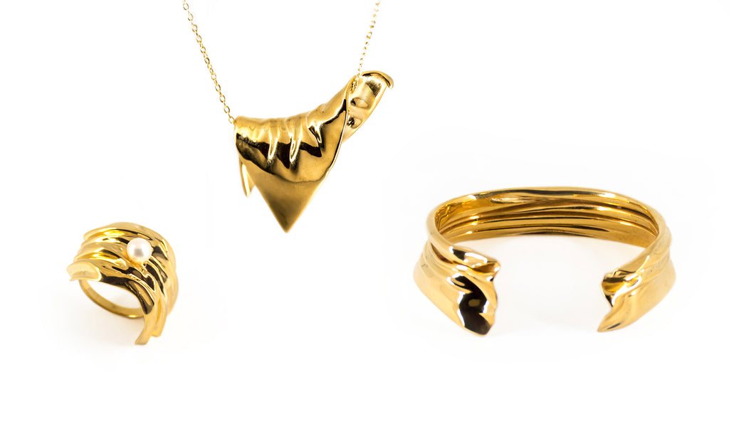 Drapery Collection in Gold showing Cambré Ring, Entrelacé Bracelet and Triangle Plié Pendant