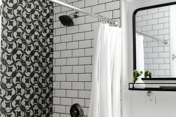 Shower with larger patterned tiles and white subway tiles