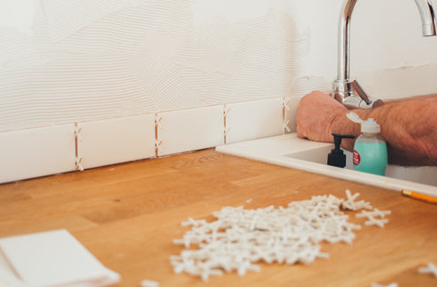 Man installing tile backsplash