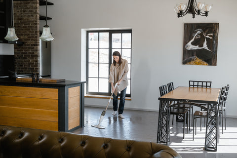 Woman applying sealer to tile floor with mop