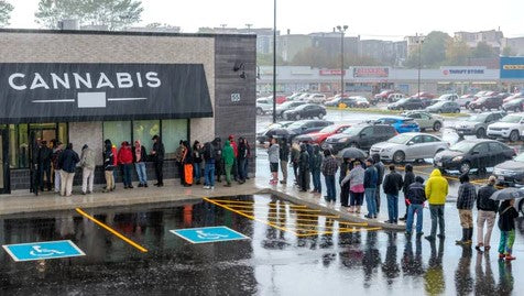 Customers line up in the rain waiting to enter a cannabis dispensary on 4/20