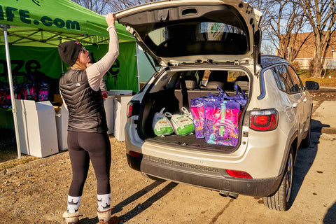 Girl loading thankgiving meals in a trunk of a silver car