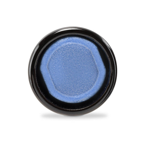 An Ooze Onyx Atomizer is turned on its side, facing the camera so the azul blue ceramic dish is in full view