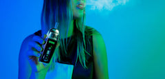 a young woman holds an Ooze Flare dry herb vaporizer in front of her body in a neon lit studio setting.