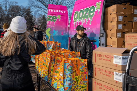 Cannatron employees are standing next to the OozeX truck filled with frozen turkeys and pies for the Oozegiving food drive.