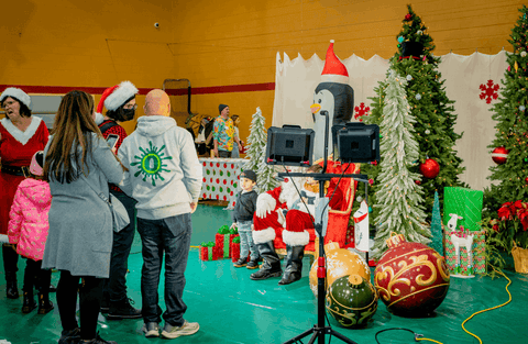 Kids are sitting on Santas lap so their parents can snap a photo at the Oozemas holiday party.