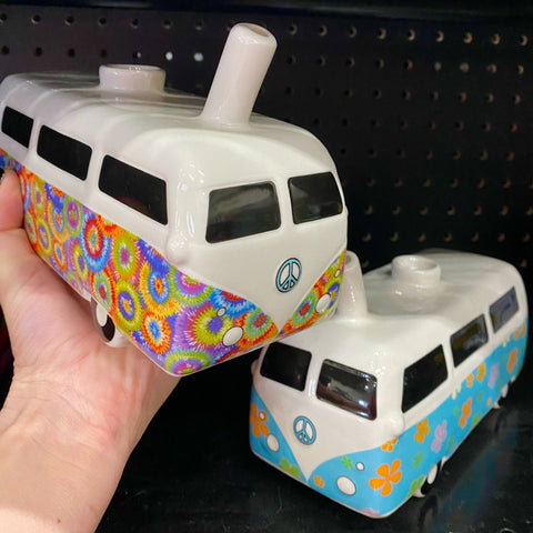 Two vintage hippie bus ceramic pipes on a smoke shop shelf