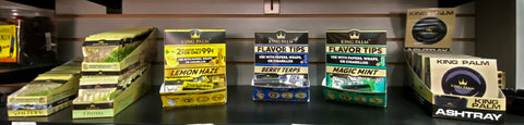 Filter tip POP Displays from King Palm are displayed on a black shelf in a gas station.