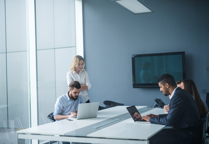 Co-workers using technology in meeting room