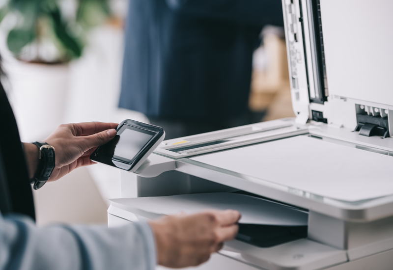 Cropped view of man using multifunction office copier