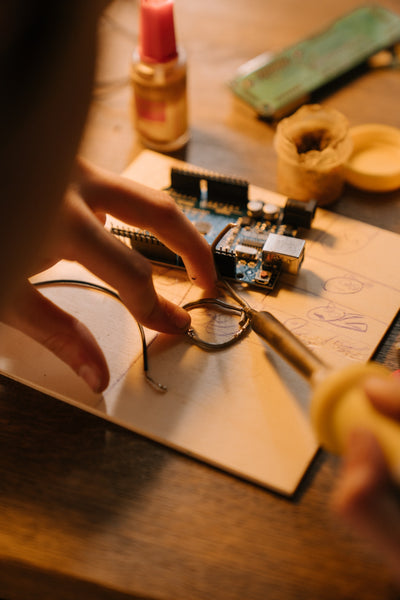 A person soldering a circuit board