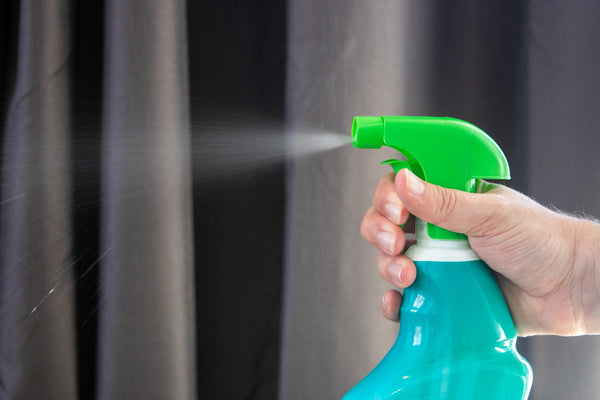 A person spraying disinfectant