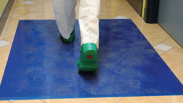 A man walking through a blue color mat 