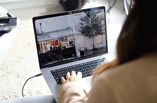 Woman charging her Macbook with her Chargeasap Infinity Magnetic Cable. Blonde woman sitting on a couch Facetiming on her gold iPad that's being charged with her Infinity magnetic cable. First universal magnetic charging cable to support 100W PD Charge, QC3.0/4.0 & Data Transfer for Apple, Micro USB, USB C & USB-C Laptops including Macbook Pro.