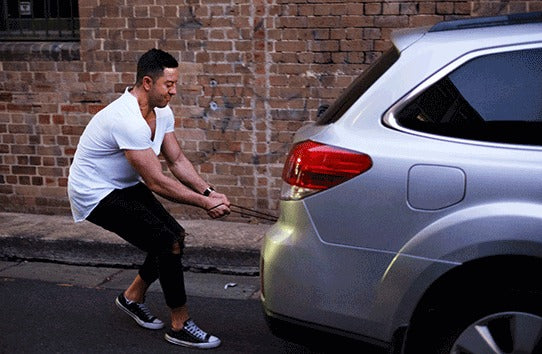 Man in a white t-shirt pulling a silver sedan with his Infinity magnetic cable. First universal magnetic charging cable to support 100W PD Charge, QC3.0/4.0 & Data Transfer for Apple, Micro USB, USB C & USB-C Laptops including Macbook Pro.