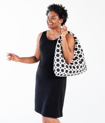 woman wearing black tunic and carrying a polka dot hobo bag