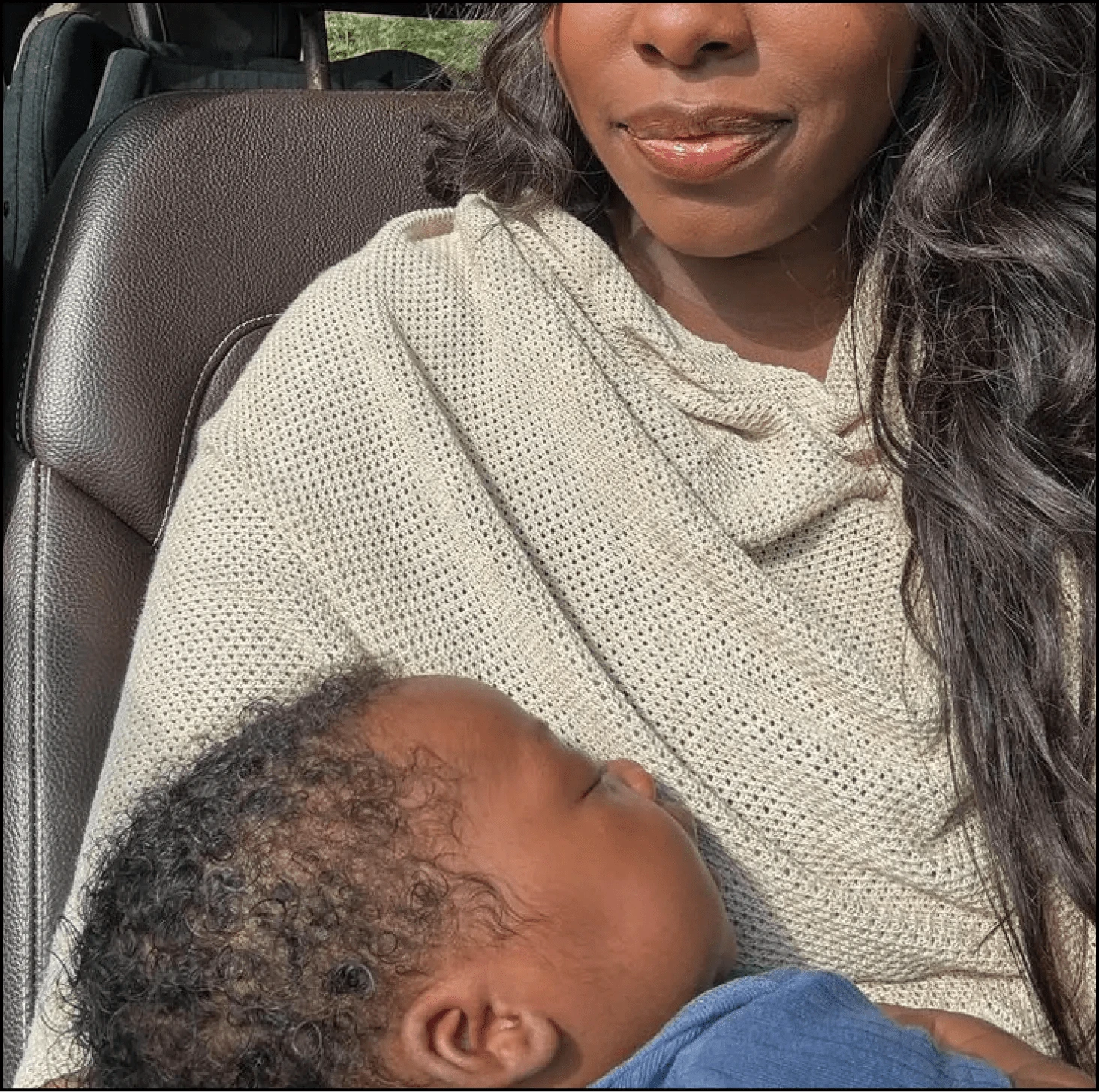 A woman lovingly holds a sleeping baby in her arms.
