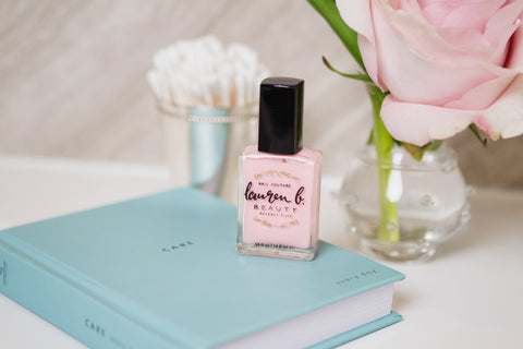 Lauren B. Nail Polish- Light Pink on a blue book with pink rose in the background