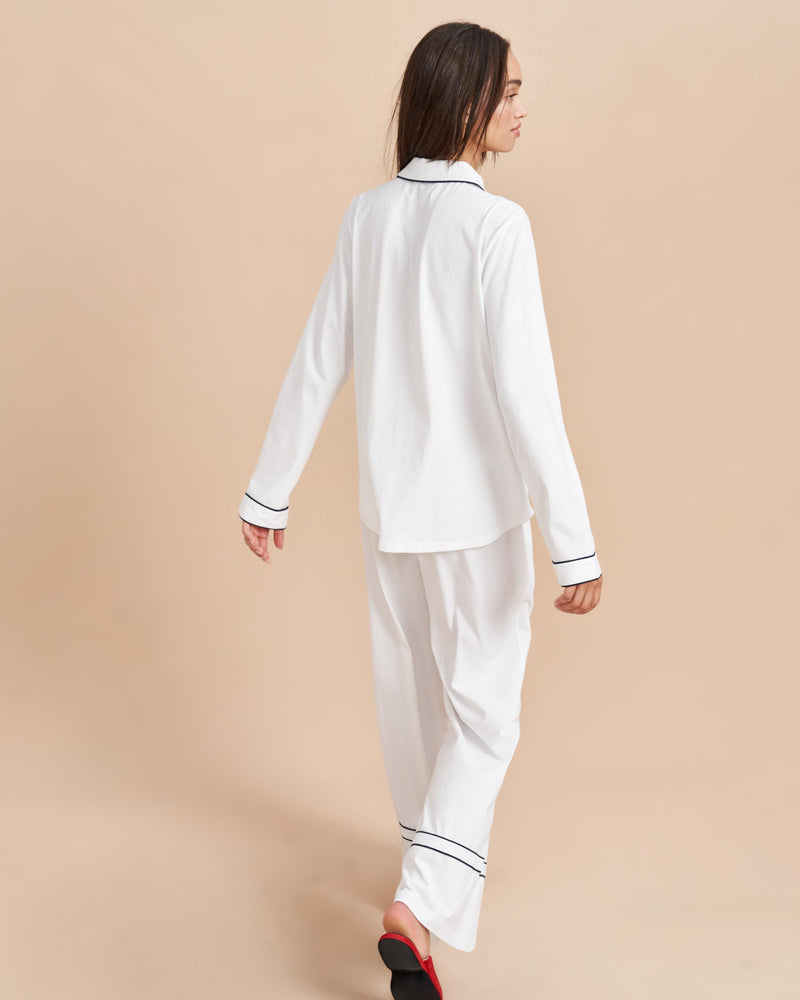 Pajama party ready. Our PJs are cut from our super soft t-shirt fabric for the ultimate in comfort and style when you need a little hygge. White cotton framed with contrasting navy piping, our PJ set has a relaxed-fit top and elasticated drawstring wide-leg pants.