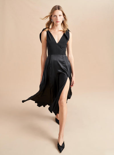 Be a vision in this softer than silk dress in a rich black, featuring adjustable ties at the shoulder and a smocked back for ease. Don't worry, we didn't forget the pockets on this one, cleverly hidden in the contrast matte lining which flares out with movement.