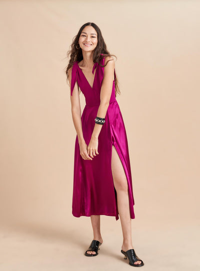 Be a vision in this softer than silk dress featuring adjustable ties at the shoulder and a smocked back for ease. Don't worry, we didn't forget the pockets on this one, cleverly hidden in the contrast matte lining which flares out with movement.