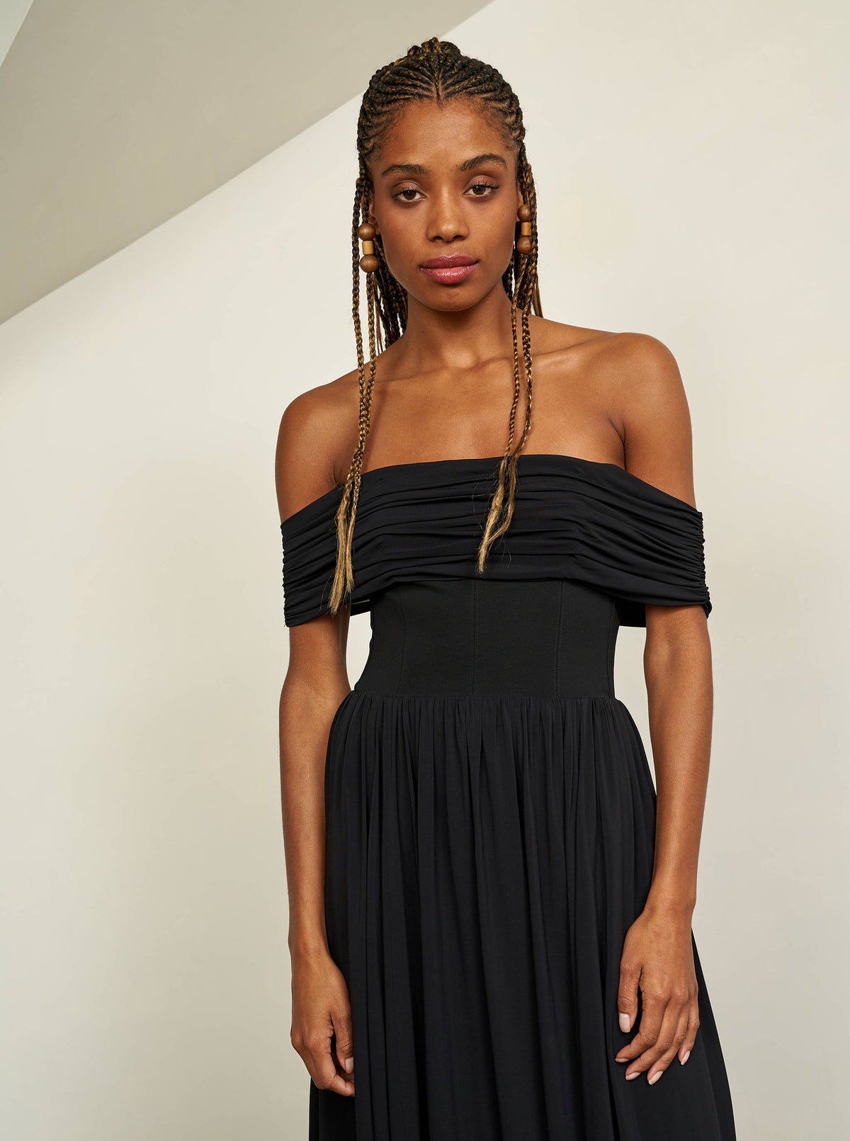 Channel your inner Grace Kelly and slip into this sleek, off-the-shoulder black dress with stretch bodice for the ultimate perfect fit.