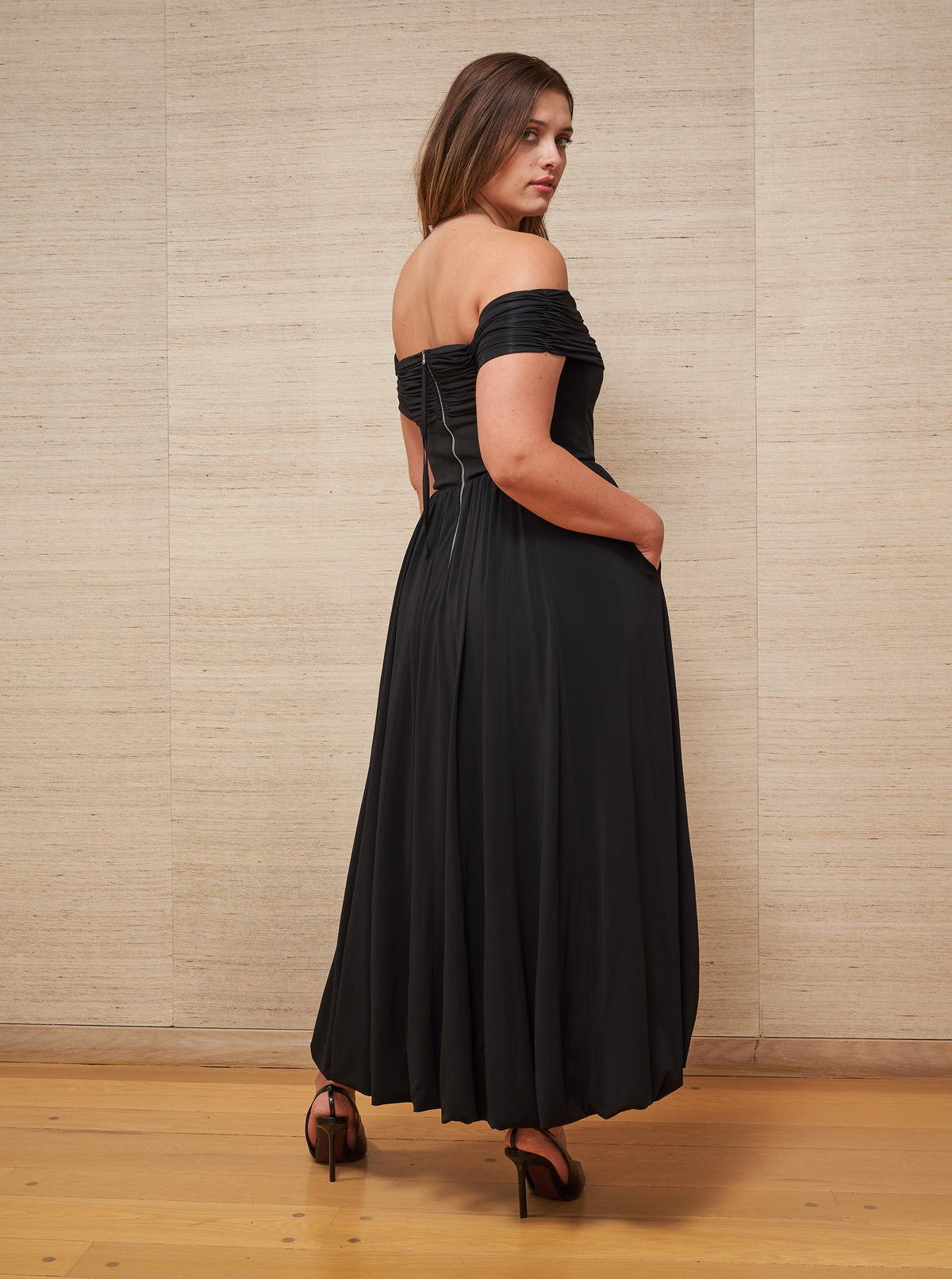 Channel your inner Grace Kelly and slip into this sleek, off-the-shoulder black dress with stretch bodice for the ultimate perfect fit.