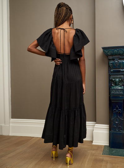 Make an entrance in this bewitching, black ruffle sleeve dress with open neckline. Equal parts romantic yet serious, the open back features a spaghetti strap adjustable tie for support as well as a smocked back for additional ease. Add some shirred tiers to this linen blend beauty and you have the perfect recipe for your dream dress this season.
