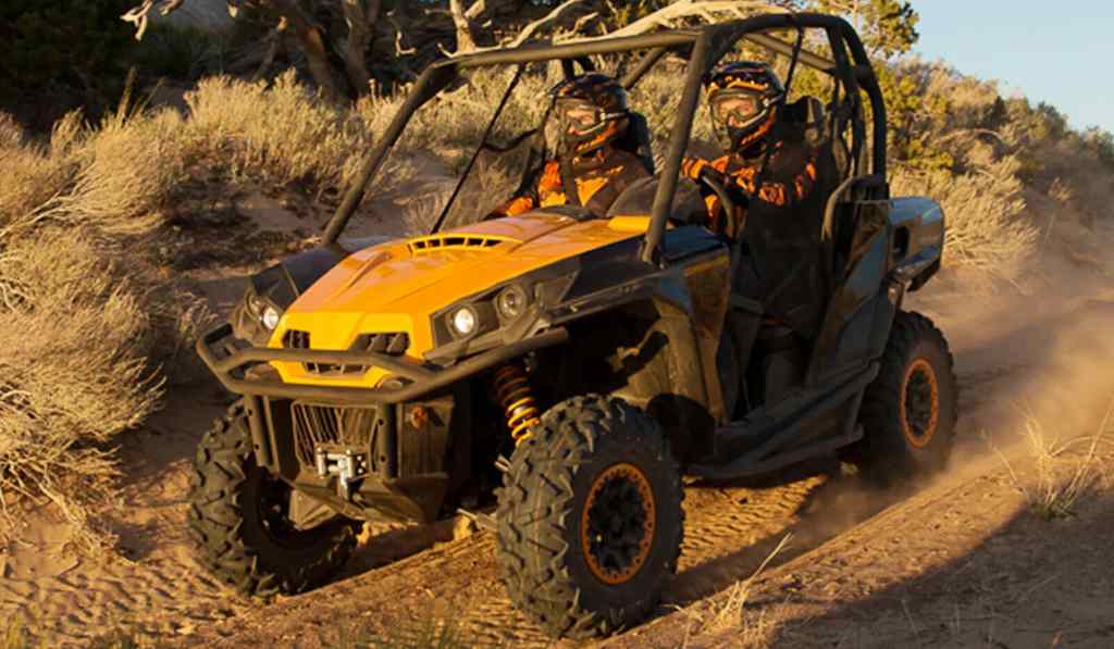 2 men riding a Cam-Am Commander on a trail